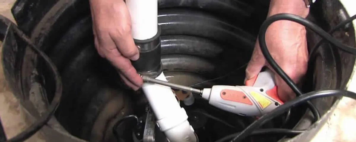 Sump pump installation technician connecting PVC discharge piping in Kenosha, WI